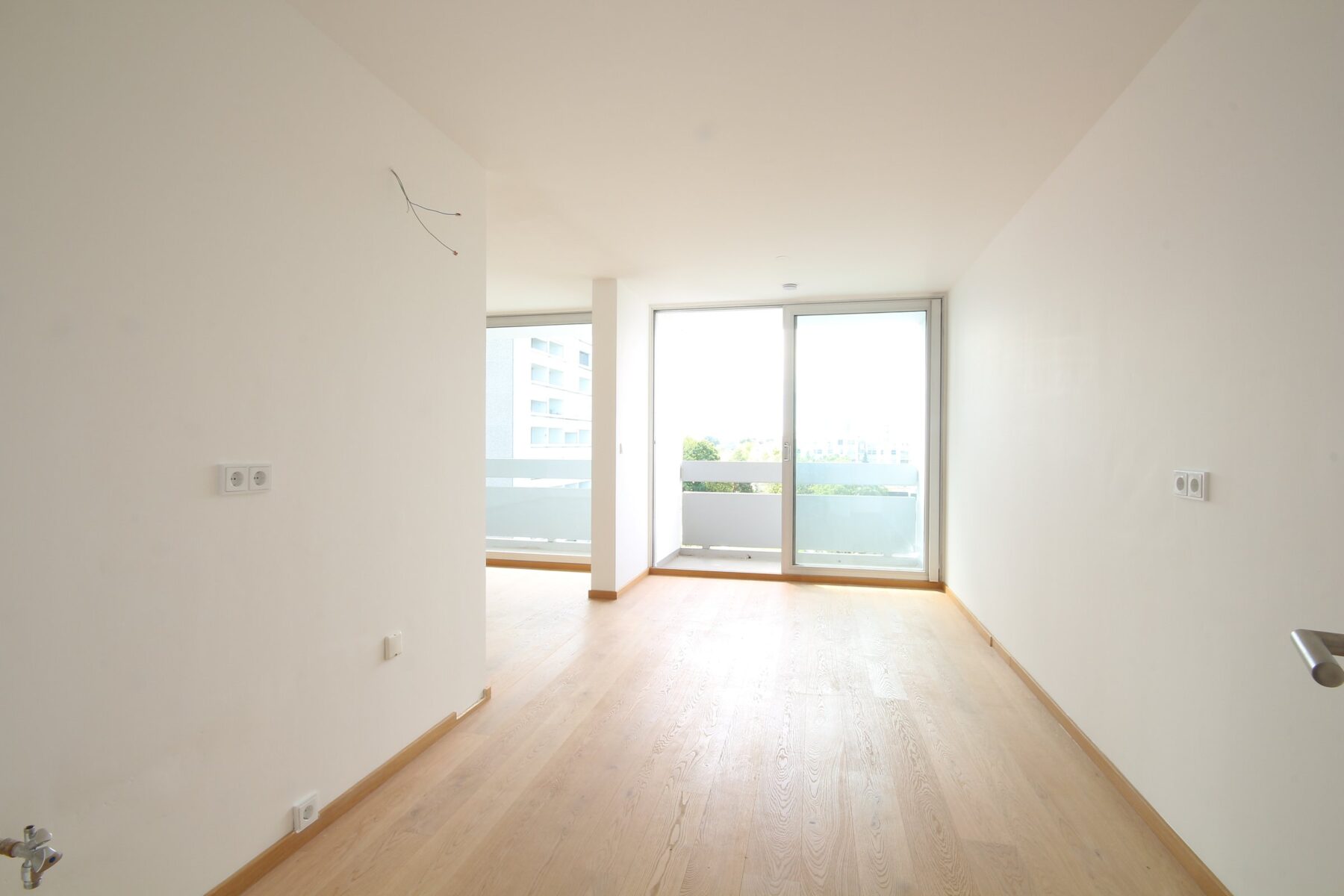 Helles Wohnzimmer mit Parkett und Balkontür – 3-Zimmer-Wohnung in München-Bogenhausen